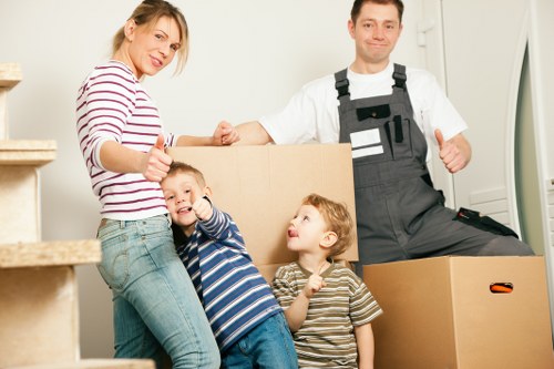 Movers carrying household items through a local apartment building